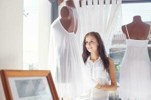 ein Frau ist Stehen im Vorderseite von ein Kleid Mannequin foto