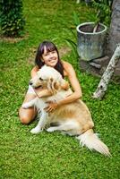 ein Frau Sitzung auf das Gras mit ein Hund foto
