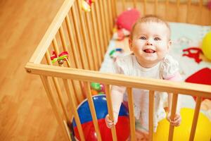 ein Baby im ein Krippe mit Spielzeuge foto