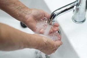 asiatische ältere ältere alte Dame Patientin beim Händewaschen im Toilettenbad der Krankenstation, gesundes medizinisches Konzept foto