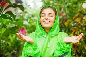 ein Frau im ein Grün Regenjacke ist lächelnd foto