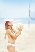 ein Frau im ein Bikini und Hut auf das Strand foto