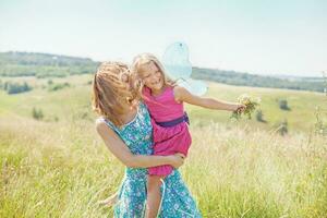 ein Frau und ihr Tochter sind Stehen im ein Feld mit Schmetterlinge foto