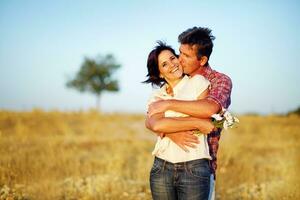 ein Mann und Frau umarmen im ein Feld foto