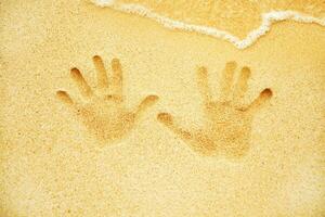 zwei Hände sind gezeigt im das Sand auf ein Strand foto