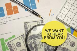 wir wollen zu hören von Sie Wörter auf Gelb Aufkleber mit Dollar mit Taschenrechner und Stift foto
