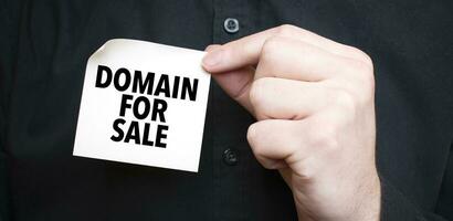 Geschäftsmann halten ein Karte mit Text Domain zum Verkauf, Geschäft Konzept foto