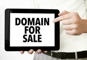 Text Domain zum Verkauf auf Tablette Anzeige im Geschäftsmann Hände auf das Weiß Hintergrund. Geschäft Konzept foto