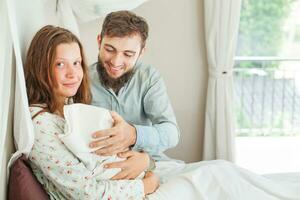 ein Frau ist Sitzung im Bett mit ein Baby foto