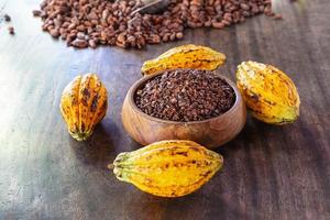 Kakaonibs und Kakaofrucht auf Holztisch foto
