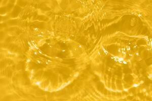 golden Wasser mit Wellen auf das Oberfläche. defokussieren verschwommen transparent Gold farbig klar Ruhe Wasser Oberfläche Textur mit spritzt und Blasen. Wasser Wellen mit leuchtenden Muster Textur Hintergrund. foto