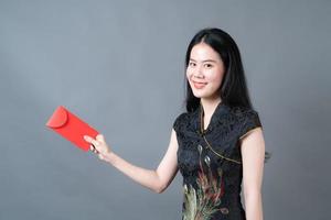 asiatische Frau trägt chinesisches traditionelles Kleid mit rotem Umschlag oder rotem Paket