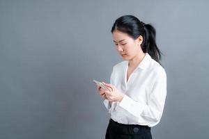 asiatische Frau, die Mobiltelefonanwendungen verwendet, die Online-Kommunikation in sozialen Netzwerken oder beim Einkaufen genießt