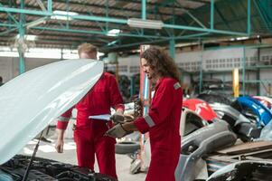 kaukasisch Handwerker sind Analysieren und Festsetzung gebrochen Auto im Auto Reparatur Mechaniker Geschäft foto