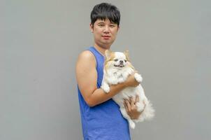 asiatisch Mann Stehen und lächelnd halten Chihuahua Hund foto