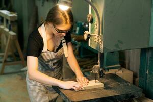 jung schön Zimmermann Frau Arbeiten mit Holz Planke, ein weiblich Kunst Arbeiter Herstellung hölzern Möbel im ein Holzbearbeitung Werkstatt. foto