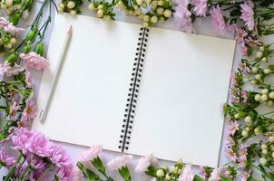 leeren Weiß Notizbuch mit Rosa Blumen auf Weiß Hintergrund. foto