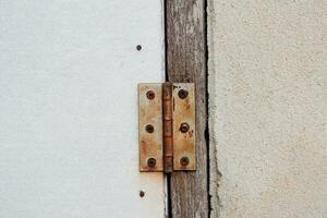 rostig alt Fenster Scharniere auf Nüsse und Holz. foto