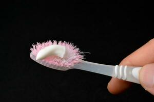 Weiß Zahnpasta auf ein Zahnbürste. schwarz Hintergrund foto