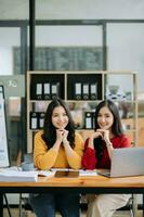 zwei attraktiv jung asiatisch weiblich Hochschule Studenten Arbeiten auf das Schule Projekt mit Laptop Computer und Tablette zusammen, genießen reden foto