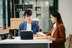 asiatisches geschäftsteam und anwälte diskutieren am tisch sitzende vertragspapiere. Rechtsbegriffe, Beratung, juristische Dienstleistungen. im Büro foto