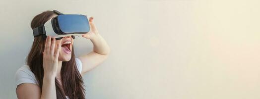 Lächeln jung Frau tragen mit virtuell Wirklichkeit vr Brille Helm Headset auf Weiß Hintergrund. Smartphone mit mit virtuell Wirklichkeit Brille. Technologie, Simulation, Hi-Tech, Videospiel Konzept. Banner foto