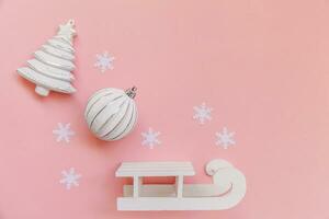 einfach minimal Komposition Winter Objekte Ornament Ball Tanne Baum Schlitten isoliert auf Rosa Pastell- modisch Hintergrund foto