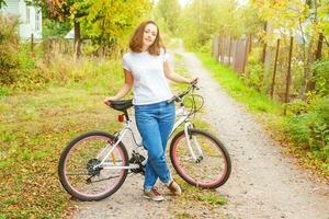 junge frau, die fahrrad im sommerstadtpark draußen fährt. aktive Menschen. Hipster-Mädchen entspannen und Fahrrad fahren. Radfahren zur Arbeit am Sommertag. fahrrad- und ökologie-lifestyle-konzept. foto