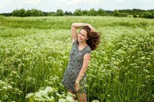 Schönheit Mädchen draußen genießen Natur. schön Frau Springen auf Sommer- Feld mit Blühen wild Blumen, Sonne Licht. kostenlos glücklich Frau. foto