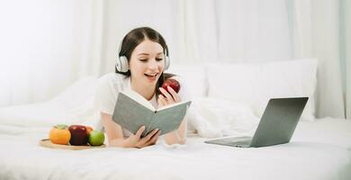 Porträt von gut gesund jung Frau lesen Buch und ruhen im Bett beim Schlafzimmer. Lebensstil Konzept foto