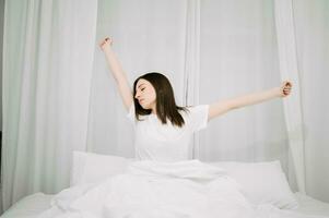 Bild von schön Frau ruhen im Weiß Bett beim Schlafzimmer. im Morgen . Lebensstil beim Zuhause Konzept. foto