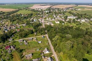 Panorama- Antenne Aussicht von Öko Dorf mit hölzern Häuser, Kies Straße, Gardens und Obstgärten foto