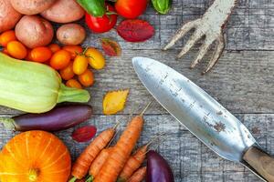 Sortiment verschiedenes frisches Bio-Gemüse und Gartengeräte auf Holzhintergrund im Landhausstil. gesundes essen vegan vegetarisches essen diätkonzept. lokaler Garten produziert saubere Nahrung. foto