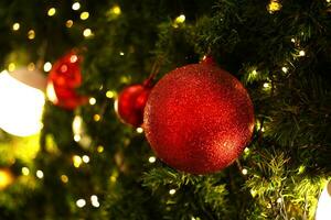 schließen oben Dekoration Ball und Licht Birne auf Weihnachten Baum beim Nacht foto