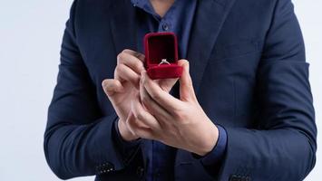 Porträt eines asiatischen Geschäftsmannes, der einen Heiratsantrag hält