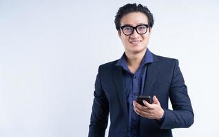 Porträt eines asiatischen Geschäftsmannes, der das Telefon benutzt foto