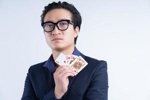 Porträt des asiatischen Geschäftsmannes, der Poker hält foto