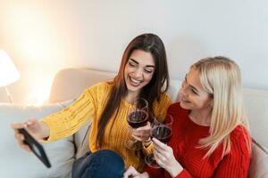 aufgeregt freunde nehmen Selfie und Lachen. Innen- Schuss von zwei emotional kaukasisch Mädchen. zwei Erwachsene Frau Herstellung Selfies mit komisch Gesichter. zwei weiblich freunde nehmen ein Selfie foto