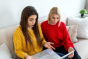 klug weiblich Studenten diskutieren Ideen zum Kursarbeit Projekt lesen Information von Netzwerk auf Laptop Computer, jung Frauen Aufpassen Lernprogramm zusammen haben Konversation im Büro foto