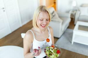 jung passen Frau Essen gesund Salat nach trainieren. Fitness und gesund Lebensstil Konzept. gesund jung Frau Essen Grün Salat foto