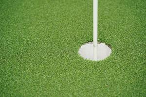 Golfloch und Flagge mit dem grünen Gras, selektiver Fokus. foto