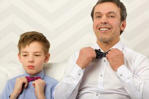 Vater und Sohn passen die Bowties an foto