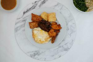 gebraten Tofu mit gebraten Ei und Erdnuss Soße auf Weiß Marmor Tabelle foto