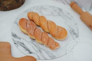 frisch gebacken Croissants auf ein Marmor Tafel mit hölzern rollen Stift foto