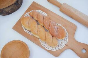 Brot Donuts auf das hölzern Tabelle mit hölzern rollen Stift. foto