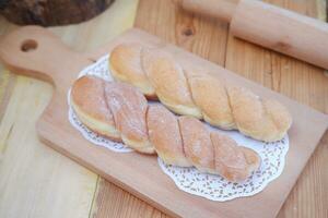 Brot Donuts auf das hölzern Tabelle mit hölzern rollen Stift. foto