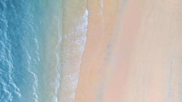 Luftaufnahme des Strandes mit smaragdblauem Wasser und Wellenschaum auf tropischem Meer foto