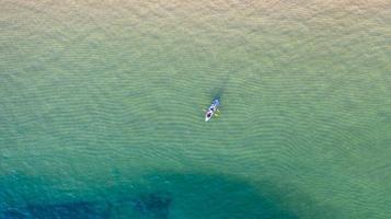 Luftaufnahme von oben auf das Kajakfahren auf dem Meer mit smaragdblauem Wasser und Wellenschaum foto