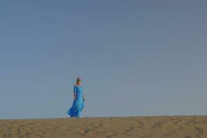 Frau im Blau Kleid gegen das Himmel foto