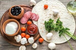 Zutaten für Pizza auf dem hölzernen Hintergrund foto